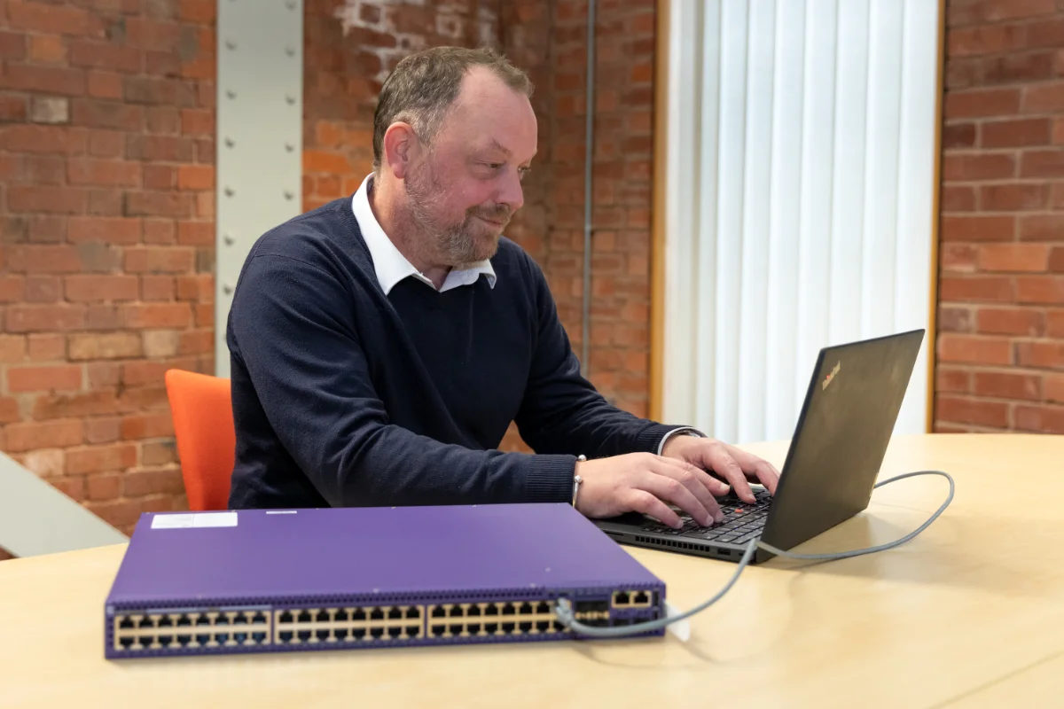 Syscom team member working on a laptop